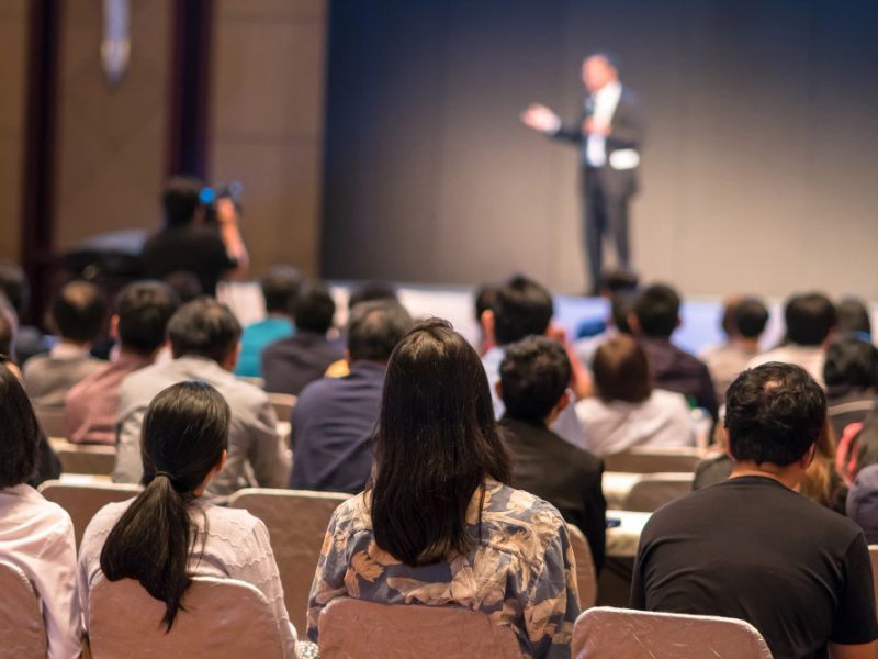 rear-side-of-audiences-sitting-and-listening-the-speackers-on-the-stage